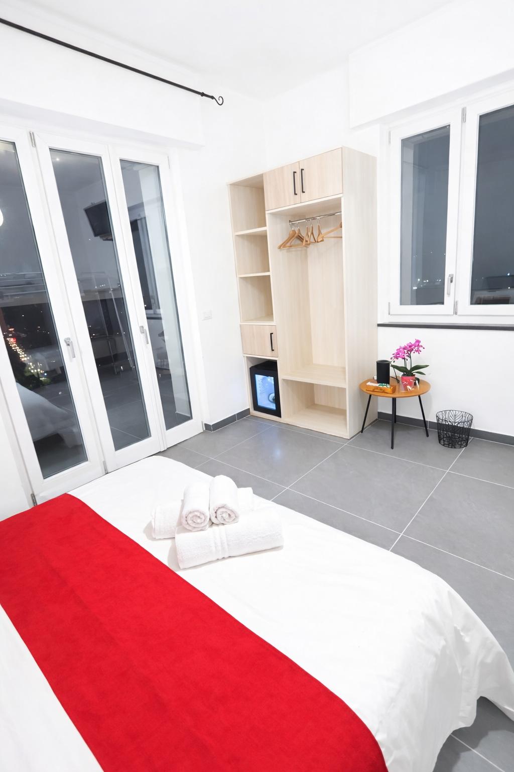 Letto matrimoniale, guardaroba e ingresso della camera Rododendro