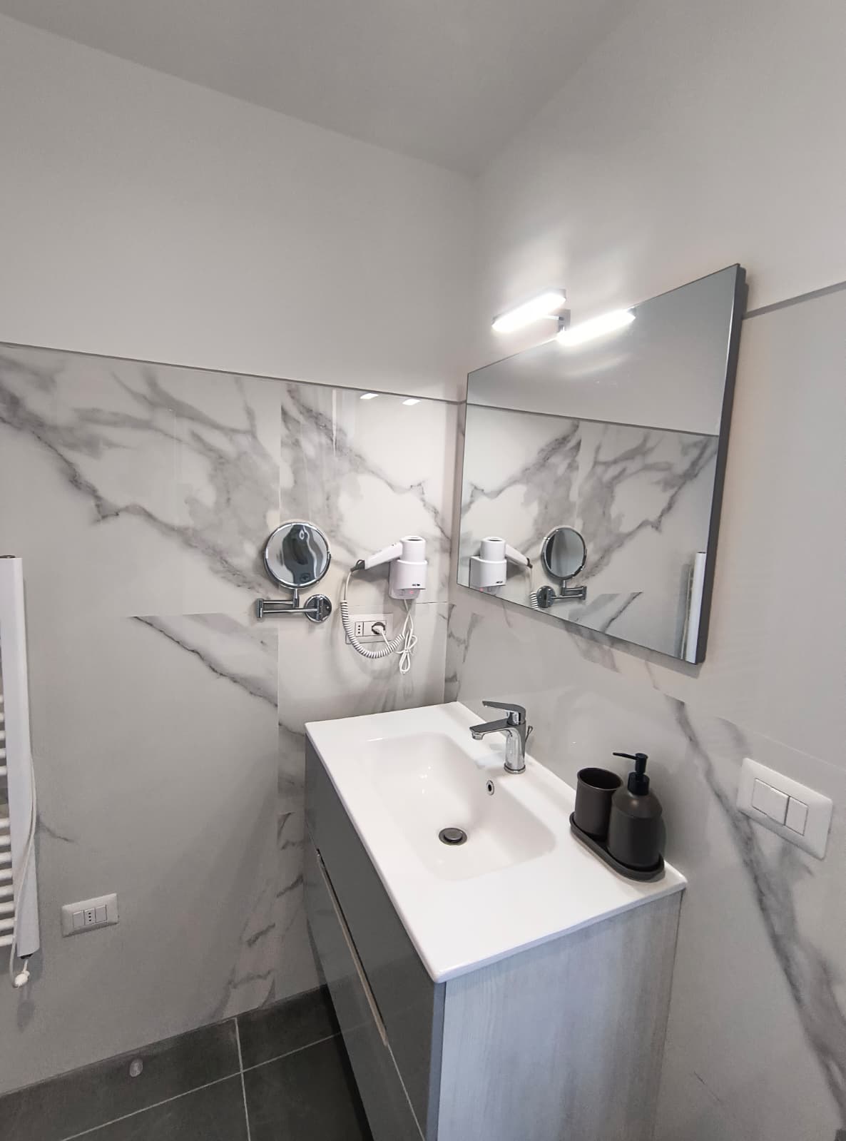 Lavabo e rivestimento effetto marmo del bagno della camera Rododendro